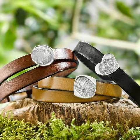 Drei Armbänder mit silberfarbenen Schmuckelementen.